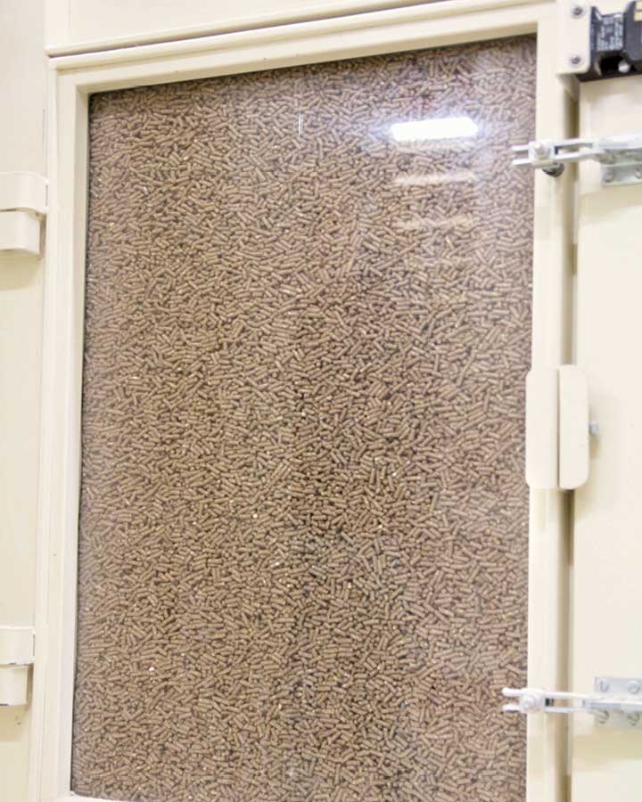À travers la fenêtre d'inspection du refroidisseur, vous pouvez voir les granulés s'enfoncer très lentement de haut en bas. Ils sont doucement refroidis par l'air et perdent de l'humidité au cours de ce processus.