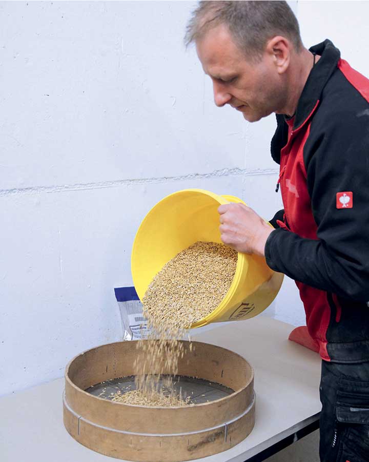 Un collègue tamise un échantillon de grain pour les pellets.